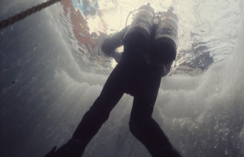 Diver surfacing through an ice hole